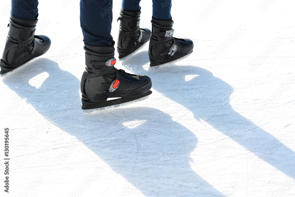 Mother and little daughter learning to skate on winter time