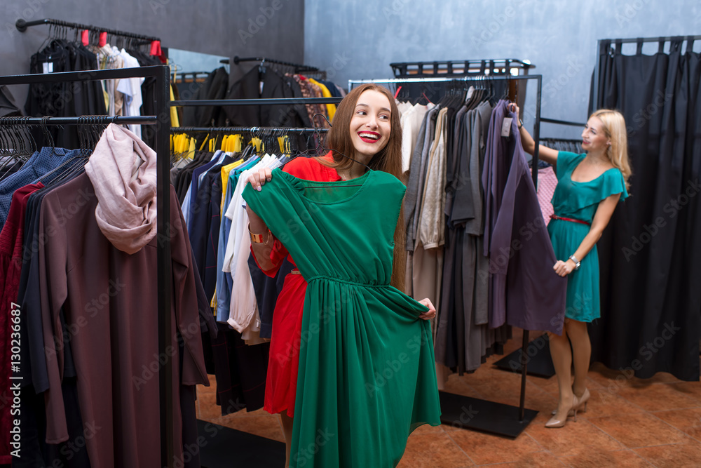 Beautiful women having fun shopping in the clothing store