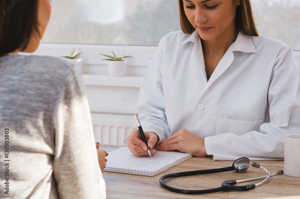 Close up of female doctor writing a medical prescription