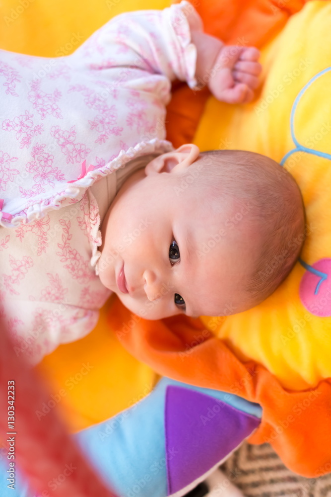 Baby girl lying on her blanket