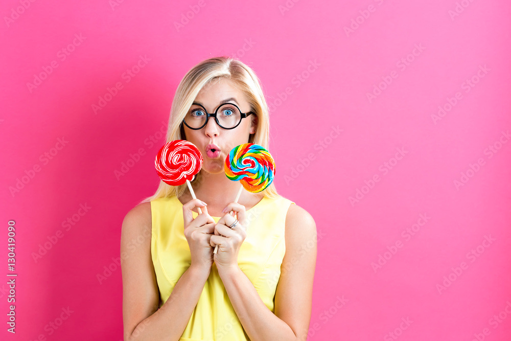 Young woman holding lollipops