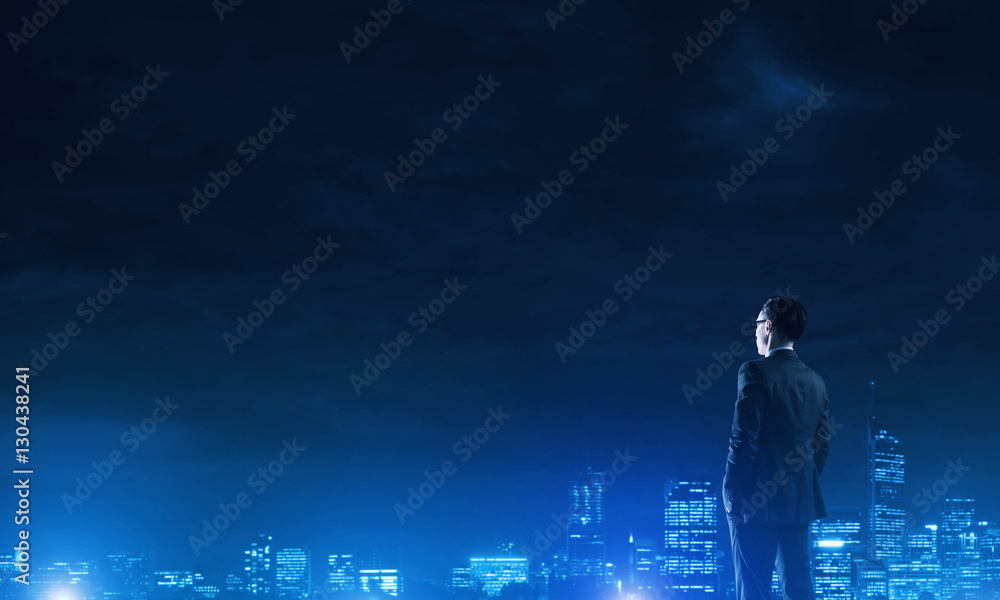 Businessman viewing night glowing city