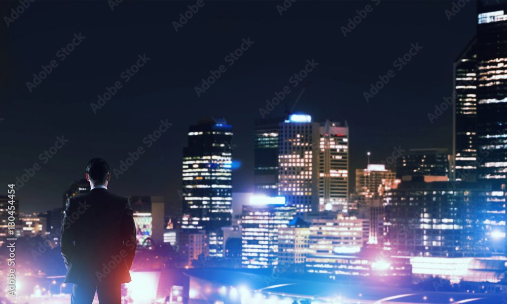 Businessman viewing night glowing city