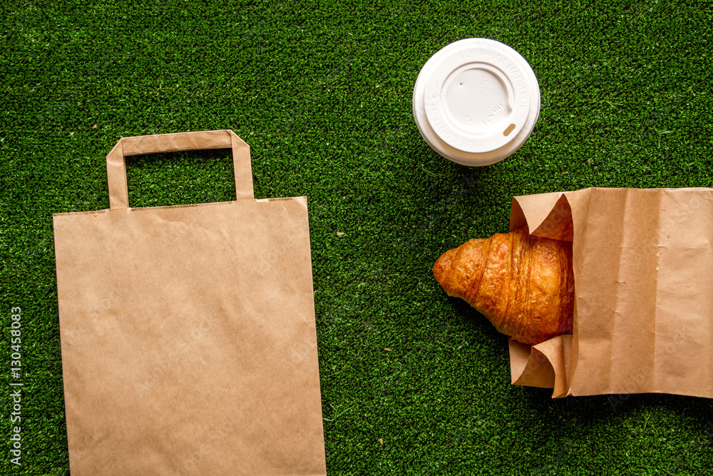 take out in paper bag on green background top view