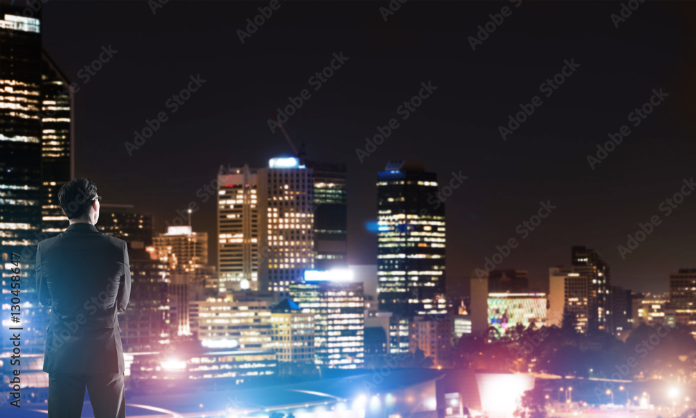 Businessman viewing night glowing city