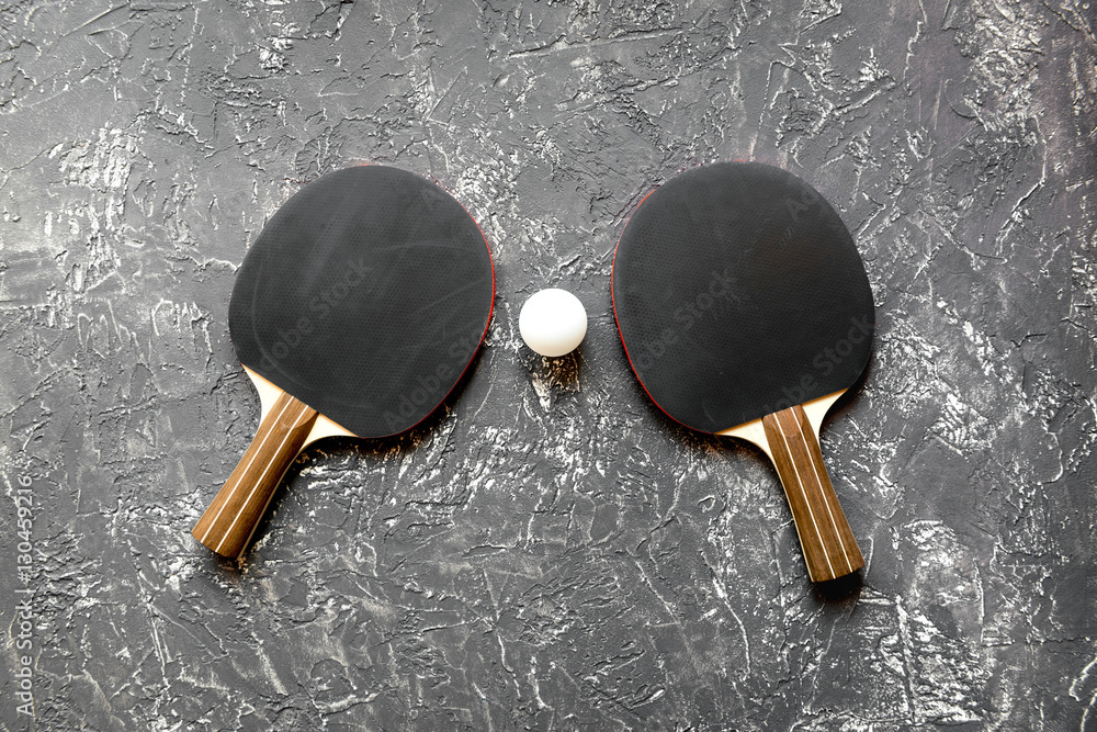 black racket for ping pong ball gray background top view