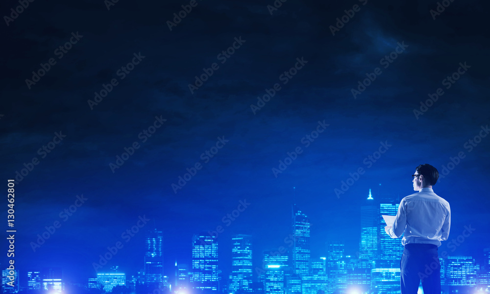 Businessman viewing night glowing city