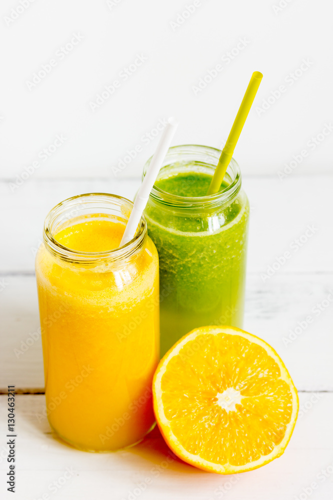 Fresh detox juices in glass bottles on white background