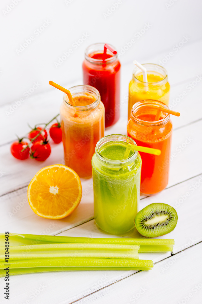 Fresh detox juices in glass bottles on white background