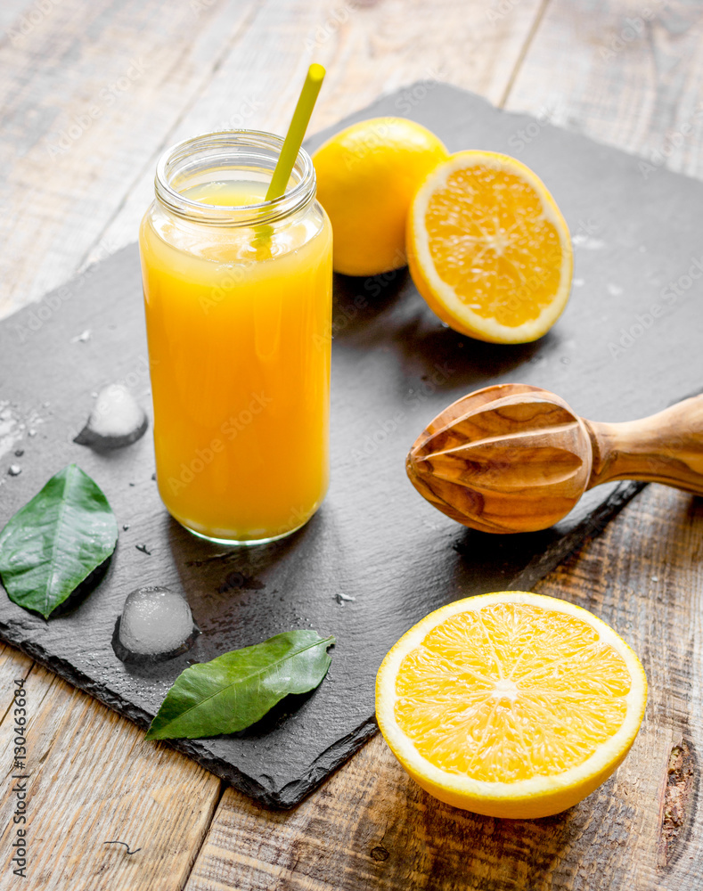 freshly squeezed orange juice in glass bottle on wooden background