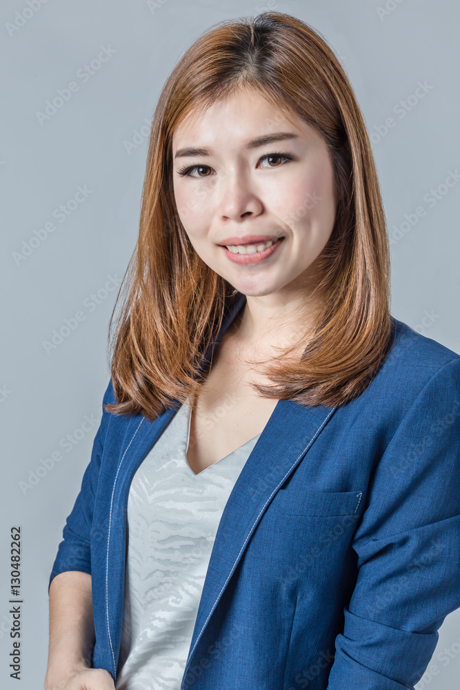 beautiful asian businesswomanwith cute smile isolated on grey ba