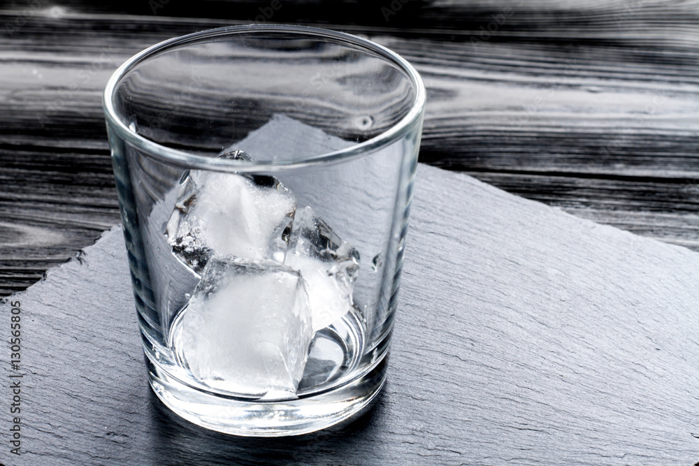 empty glass with ice on dark wooden background