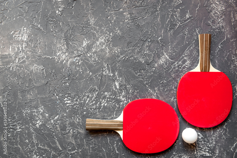 Red racket for ping pong ball gray background top view