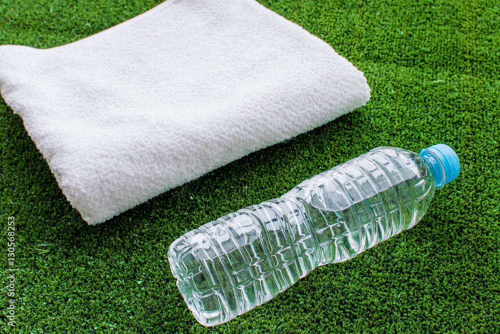 preparation for fitness water bottle and towel on green background