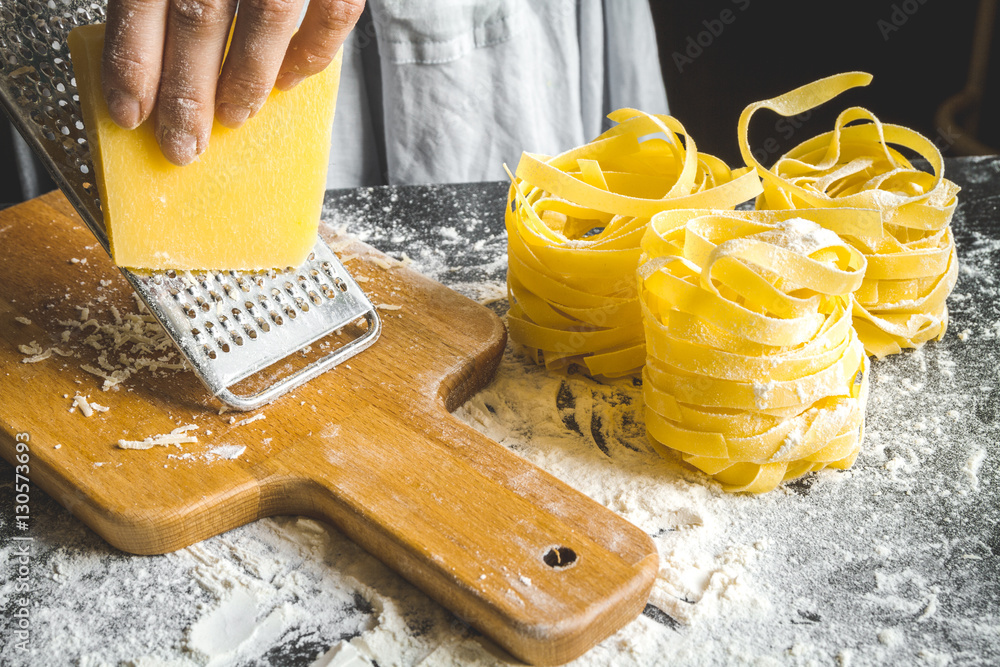 cooking pasta by chef in kitchen on dark background