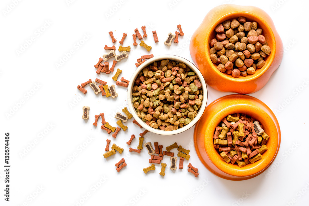 dry dog food in bowl on white background top view