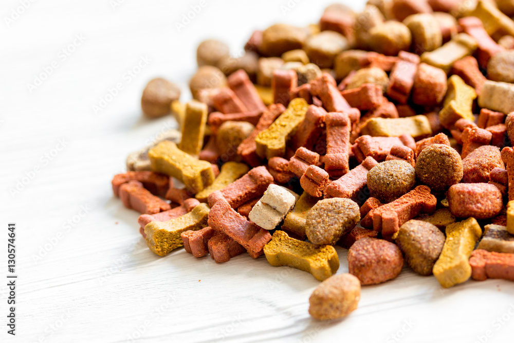 dry dog food in bulk on wooden background close up