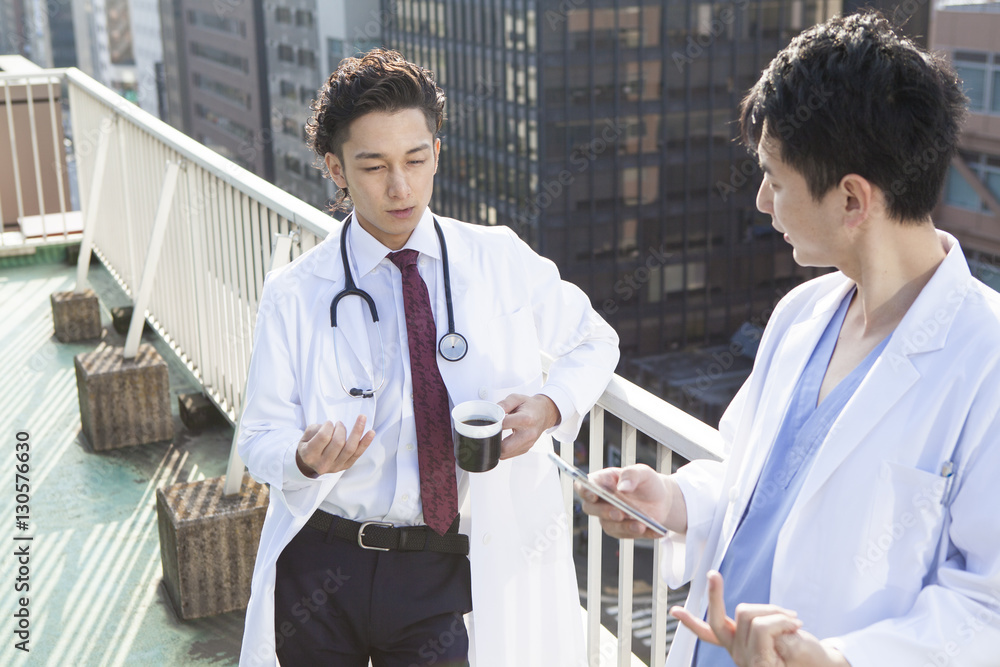 Two doctors are talking on the rooftop during a break