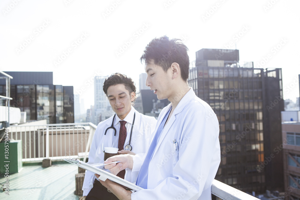 Doctors are talking while watching a medical record on the hospitals rooftop