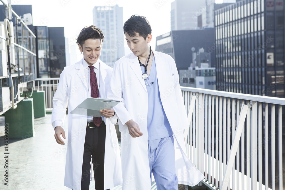 Two doctors are talking on the roof while watching the medical record