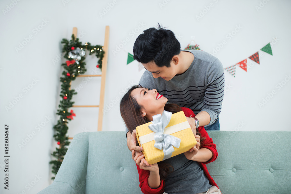 Christmas Asian Couple. A handsome man giving her girlfriend/wif