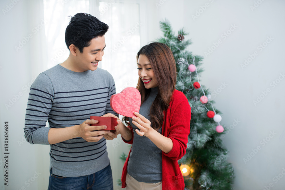 Christmas Asian Couple. A handsome man giving her girlfriend/wif