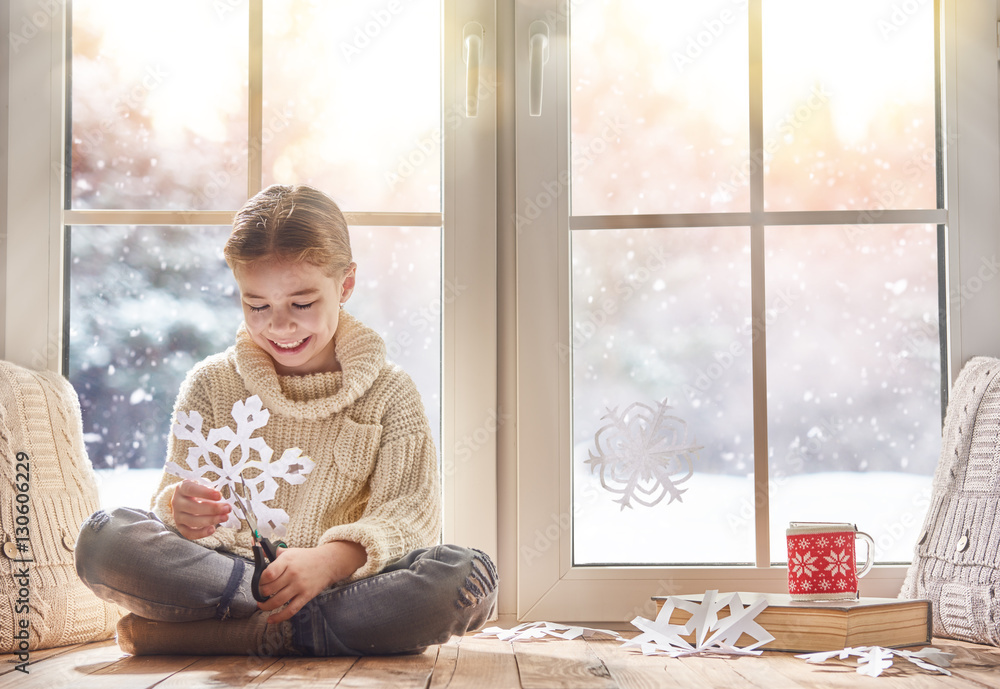 Child makes paper snowflakes