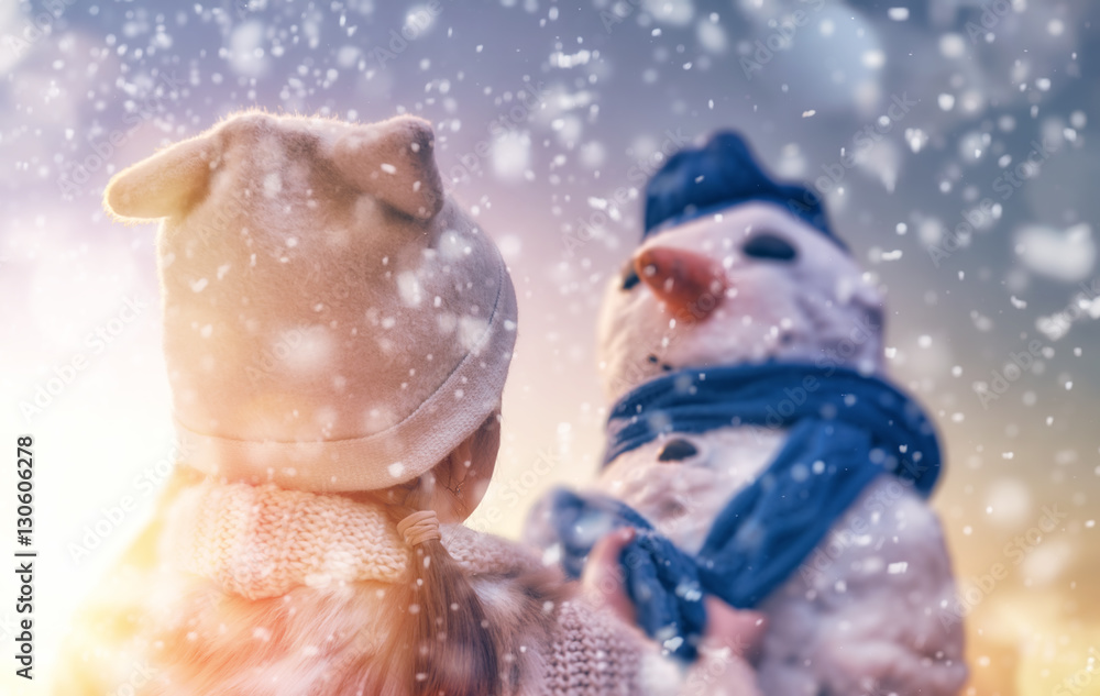 girl playing with a snowman