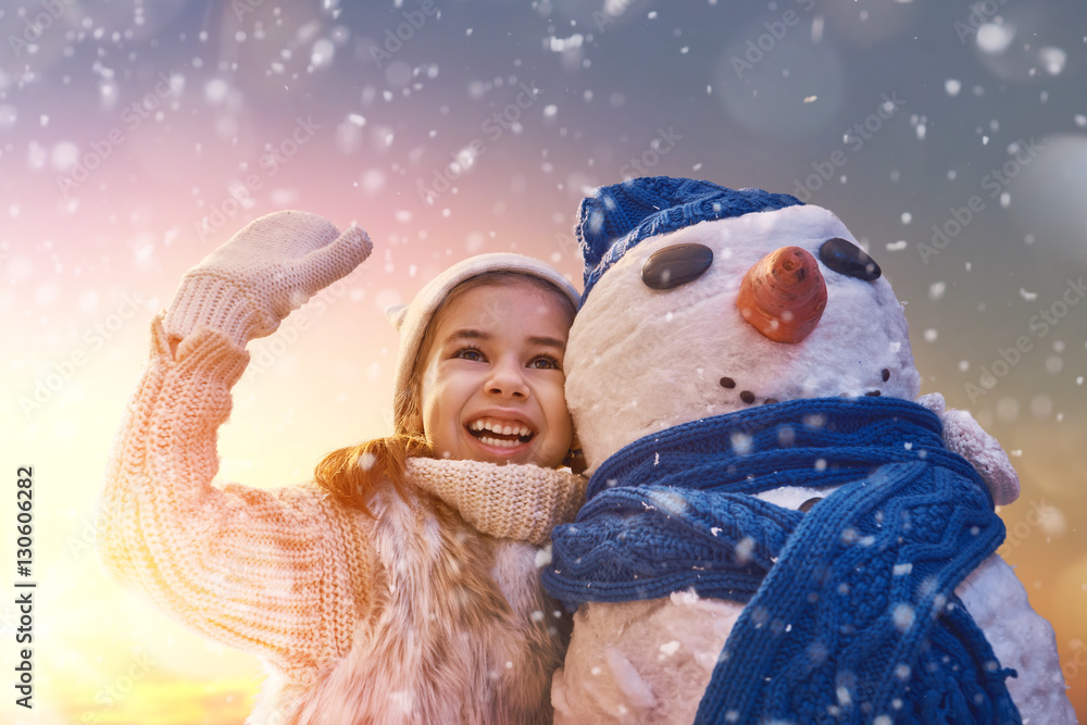 girl playing with a snowman