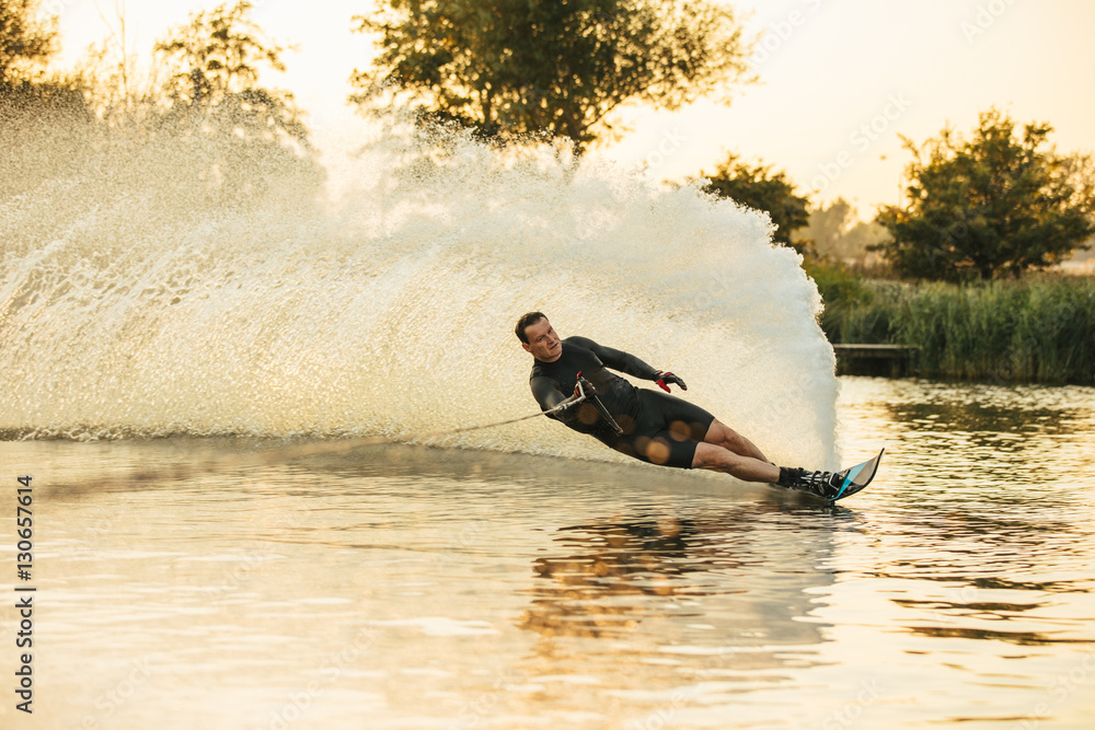 Athlete doing stunts on wakeboard in lake