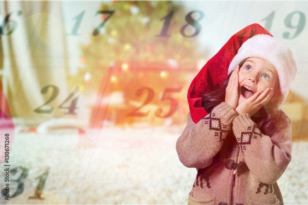 Happy child girl in a christmas hat.