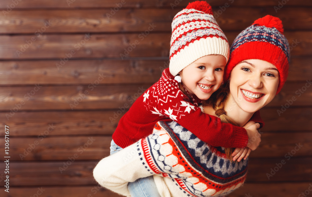 happy family mother and child girl  hugs at wooden background.