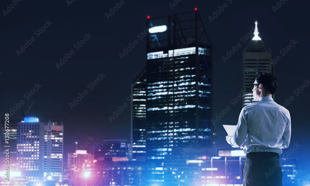 Businessman viewing night glowing city