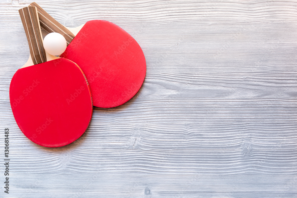 Red racket for ping pong ball wooden background top view