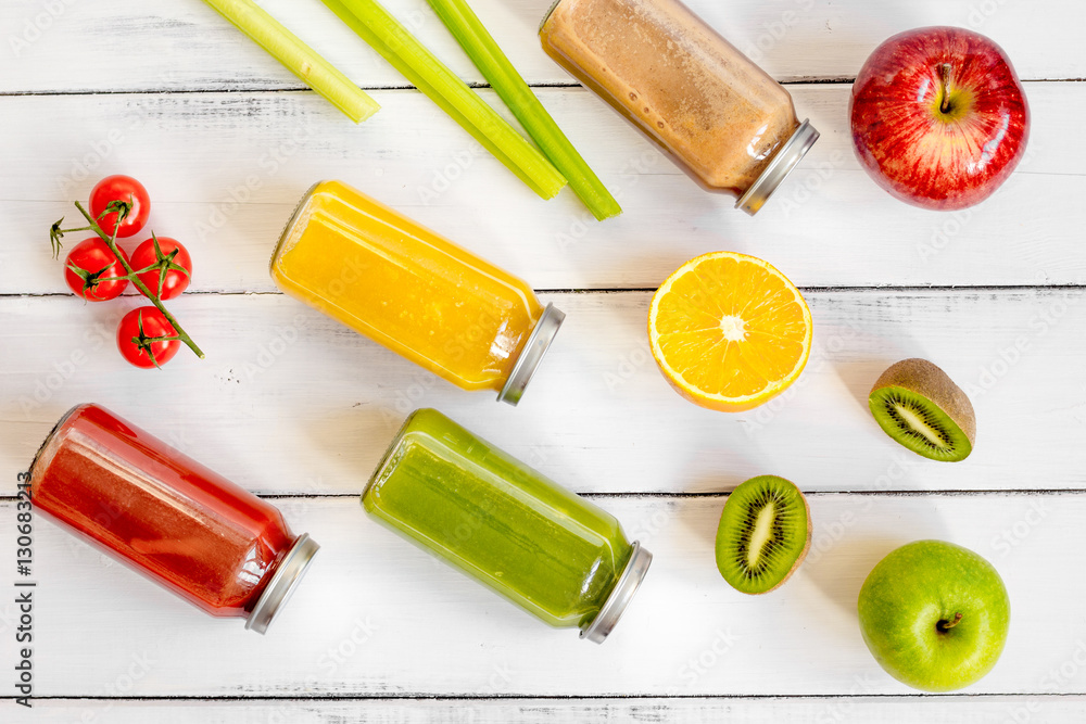 freshly squeezed juices for detox on wooden background top view