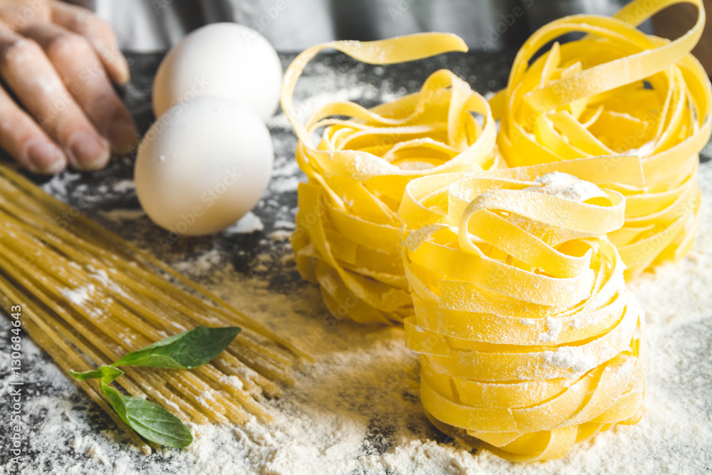 cooking pasta by chef in kitchen on dark background