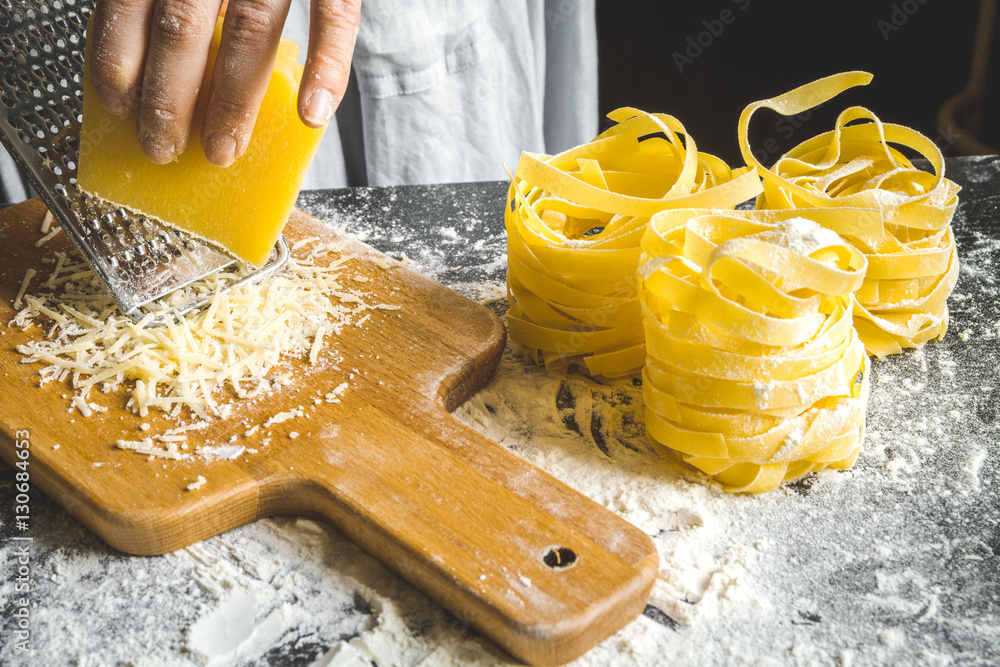 cooking pasta by chef in kitchen on dark background