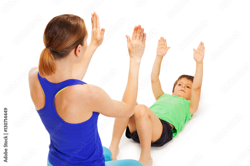 Kid boy repeating physical exercises after trainer