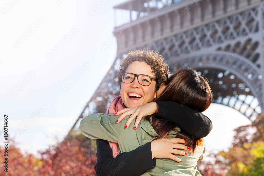 Happy meeting of friends hugging at Paris street