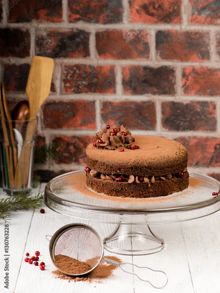 Chocolate cake with berries and cocoa powder on white wooden background. Authentic.