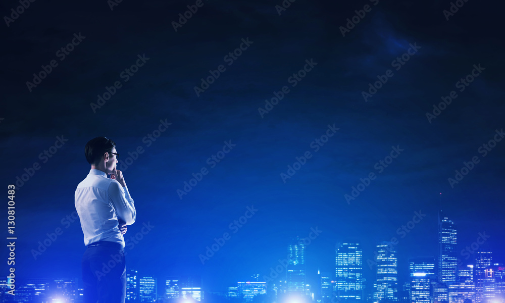 Businessman viewing night glowing city