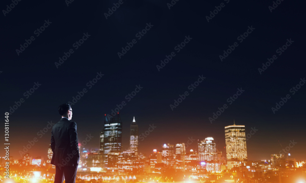 Businessman viewing night glowing city