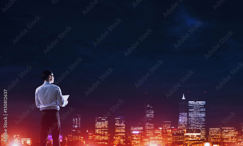 Businessman viewing night glowing city