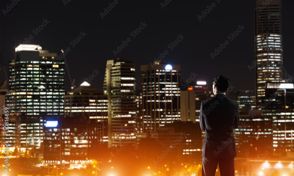 Businessman viewing night glowing city