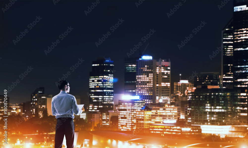 Businessman viewing night glowing city