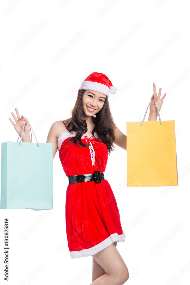 Portrait of a young smiling woman holding shopping bags before c