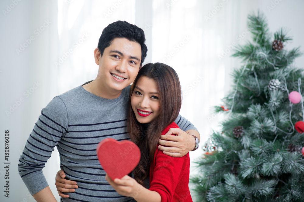 Christmas Asian Couple. A handsome man giving her girlfriend/wif