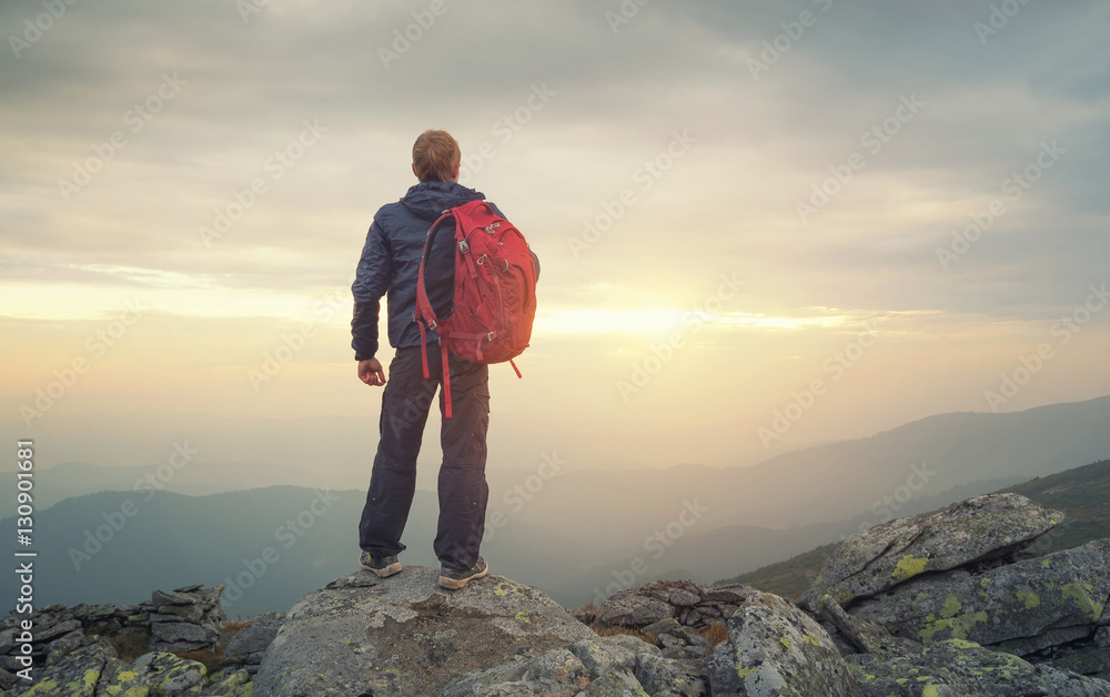 Tourist on the peak of high rocks. Sport and active life concept..