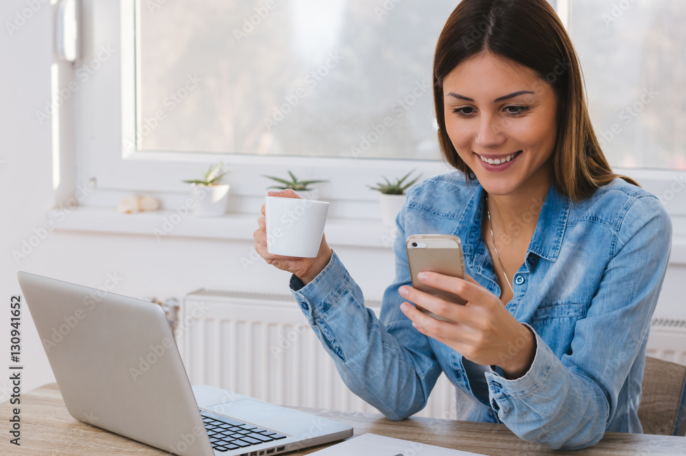 Portrait of young beautiful casual woman holding smartphone, loo