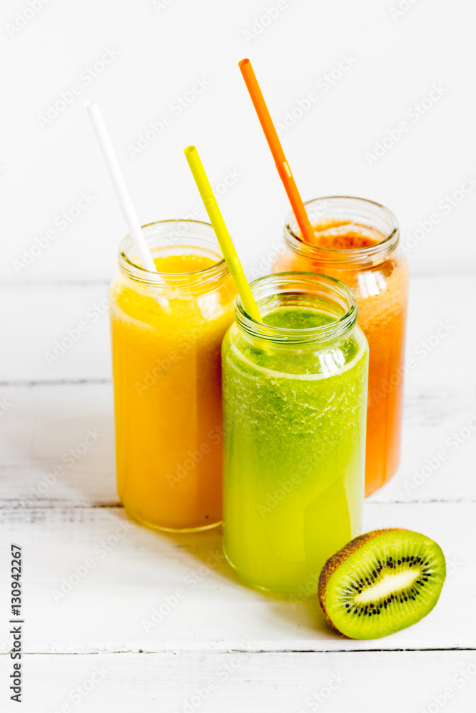 Fresh detox juices in glass bottles on white background